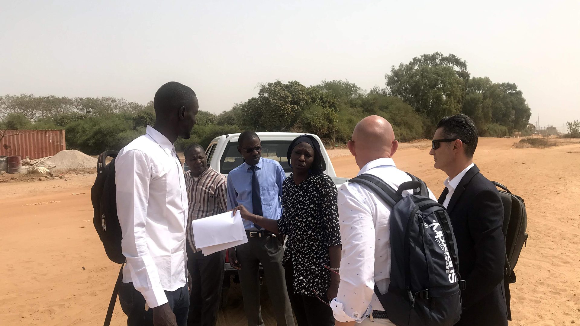 Equipo de AvalonBiz reunido con t&eacute;cnicos senegaleses sobre una pista de arena en las afueras de Dakar