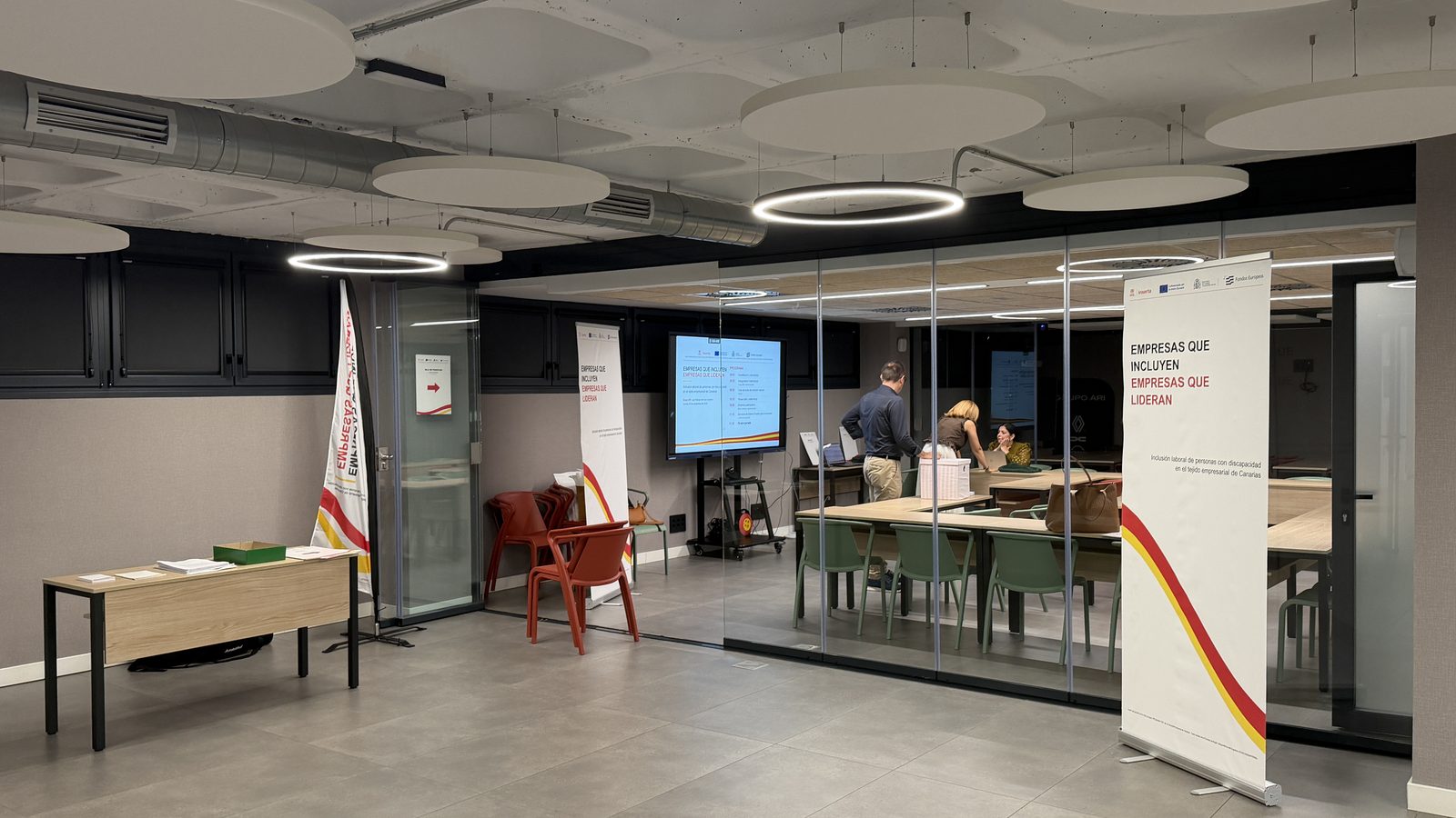 Sala de la jornada en la sede de Grupo ARI, con el roll-up del programa INSERTA-AVALON y la mesa de acreditaciones, minutos antes de empezar